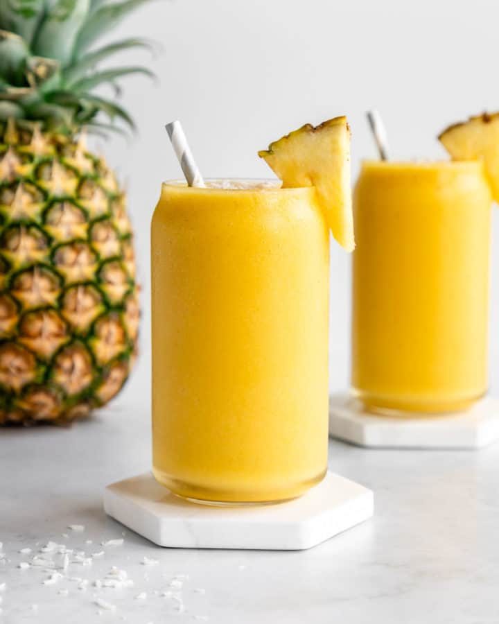 two pineapple coconut smoothies in glasses