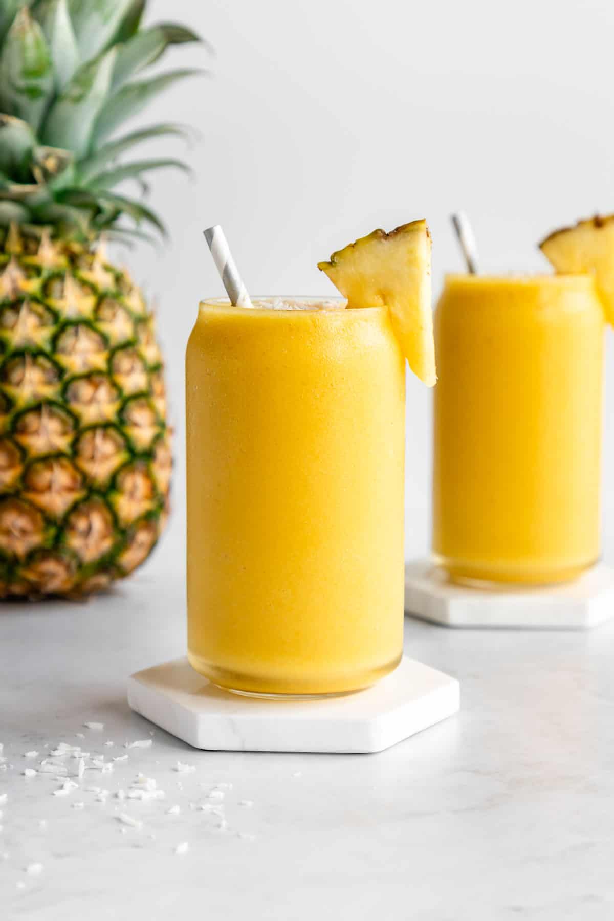 two pineapple coconut smoothies in glasses