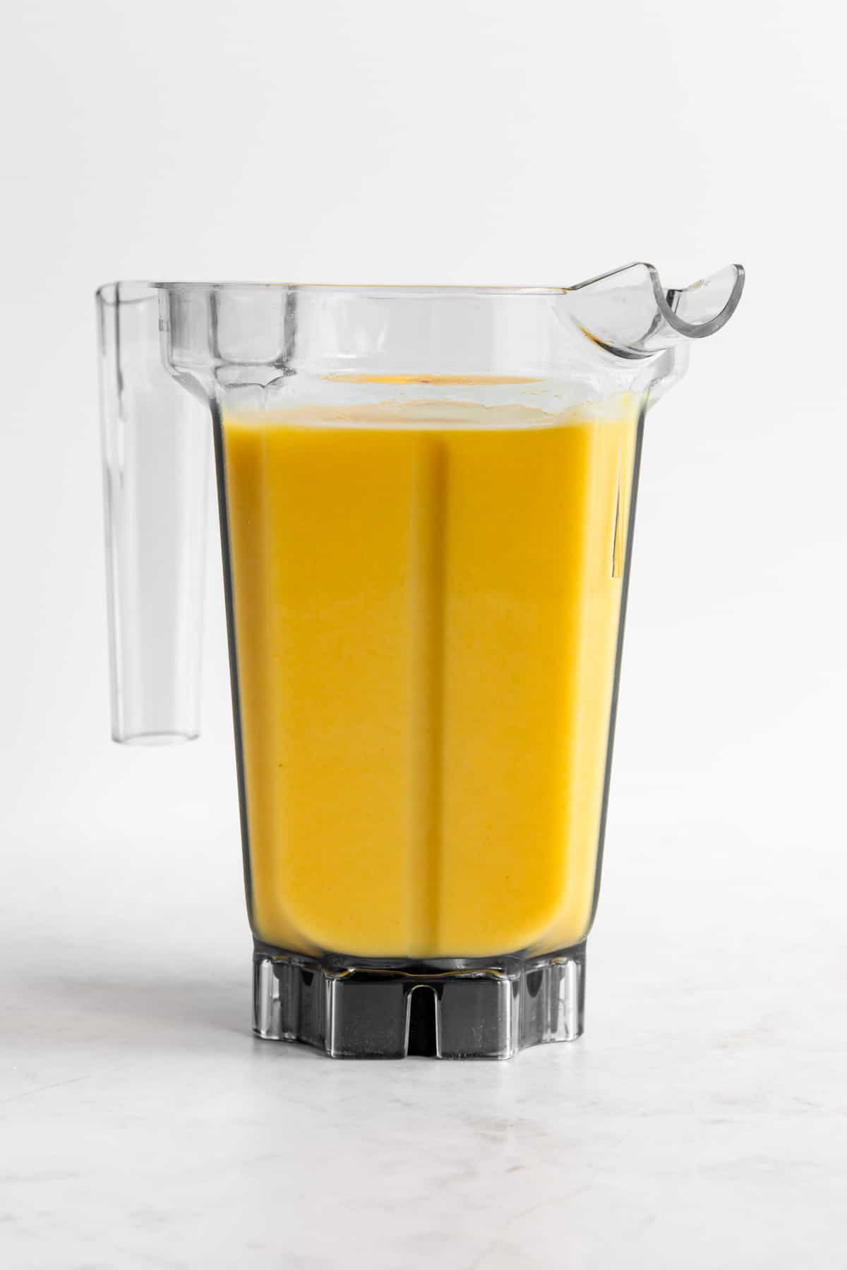 a yellow smoothie inside a vitamix blender