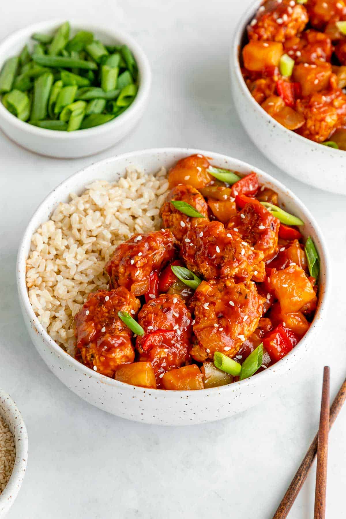 two bowls of sweet and sour vegan pork with brown rice