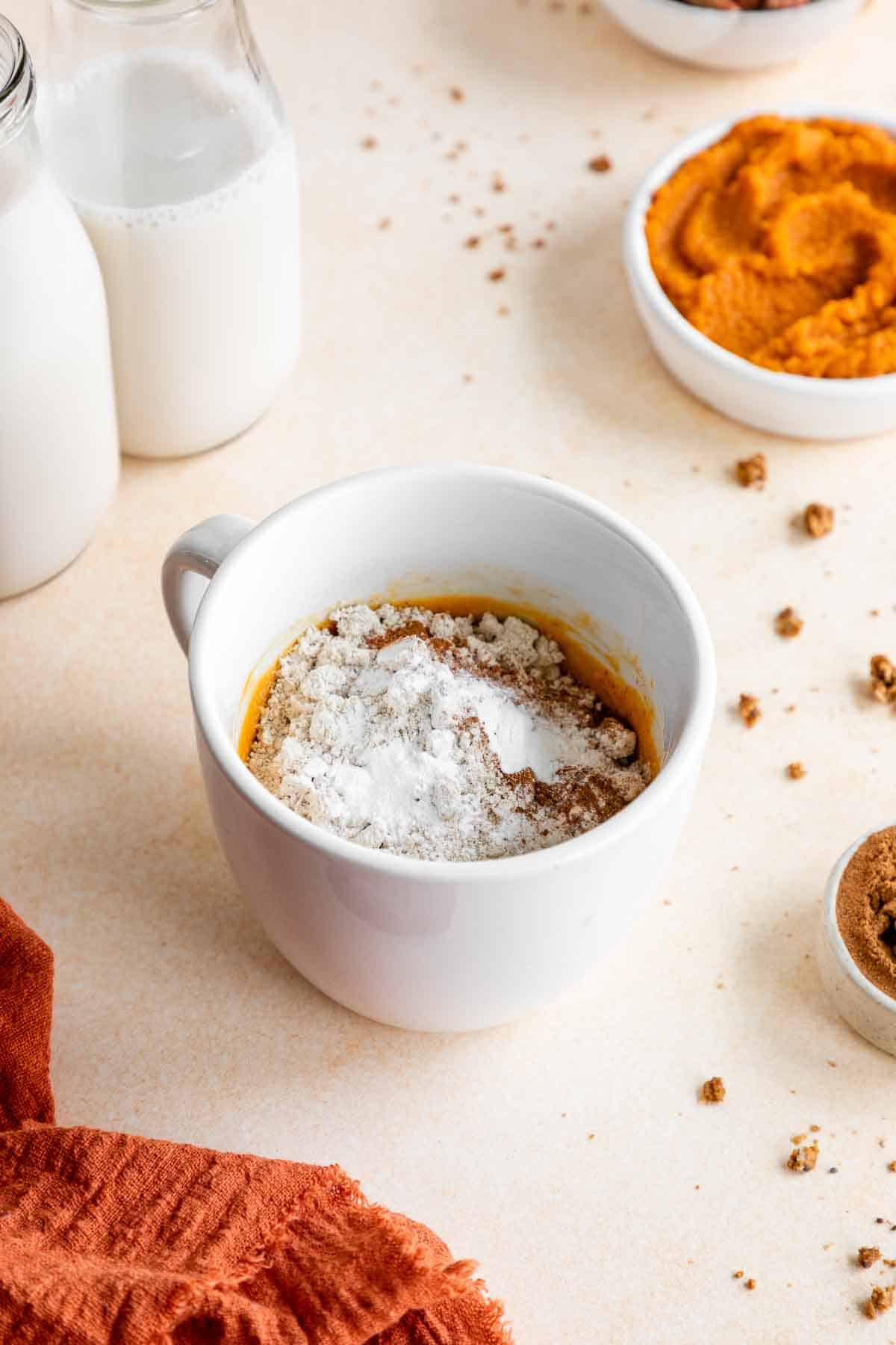 oat flour and pumpkin cake batter in a white mug