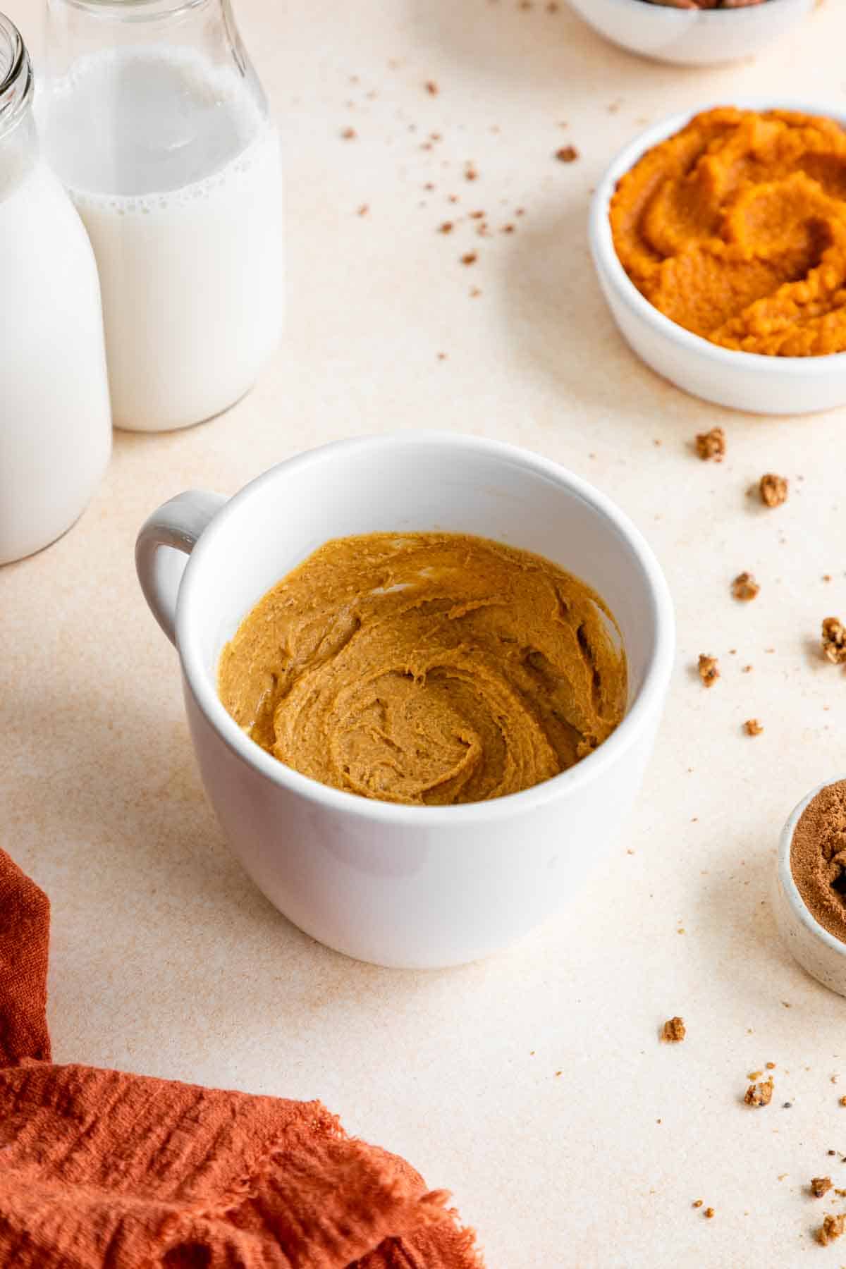 vegan gluten-free pumpkin cake batter inside a white mug