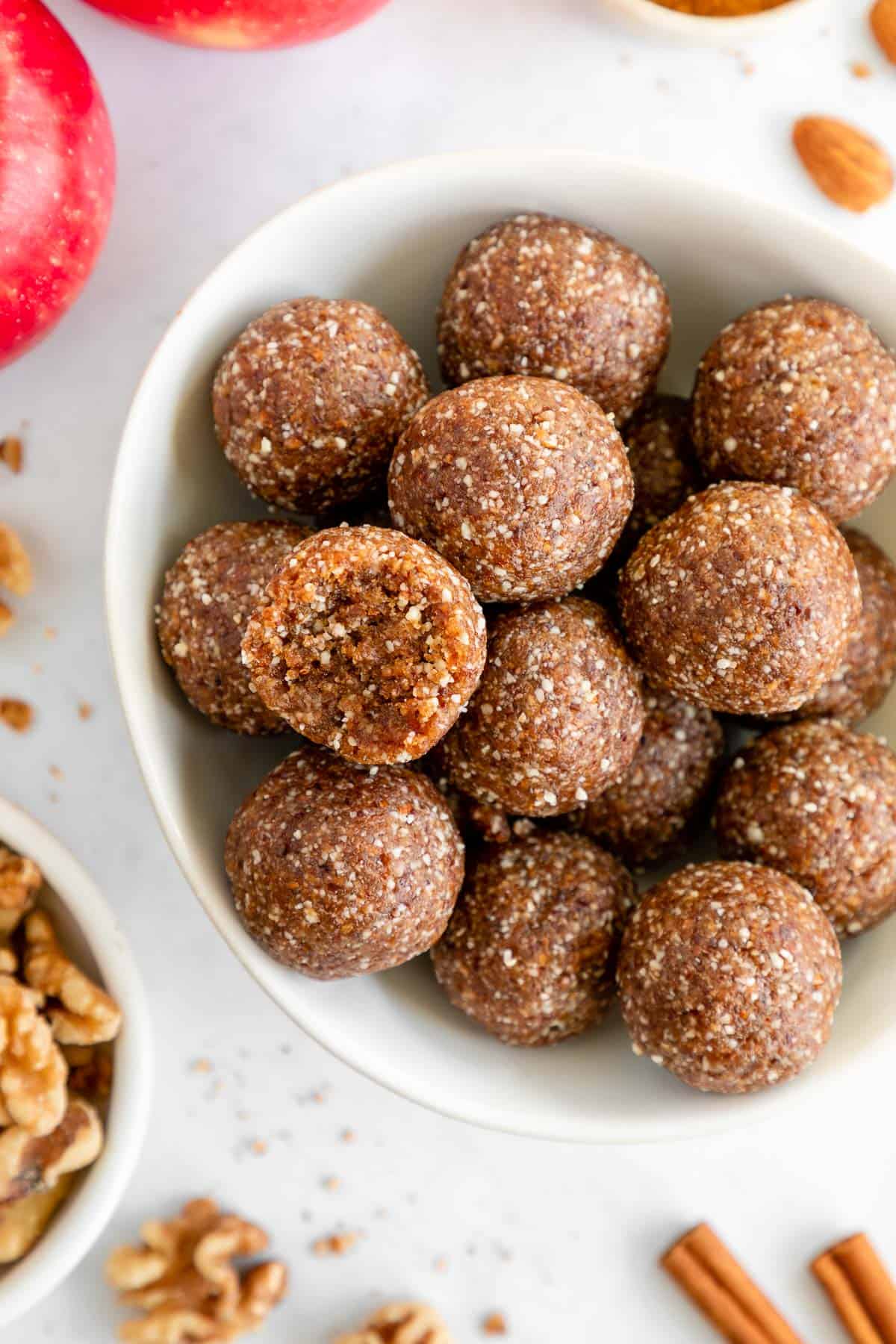 a bowl of apple pie energy bites with a bite taken out of the middle one