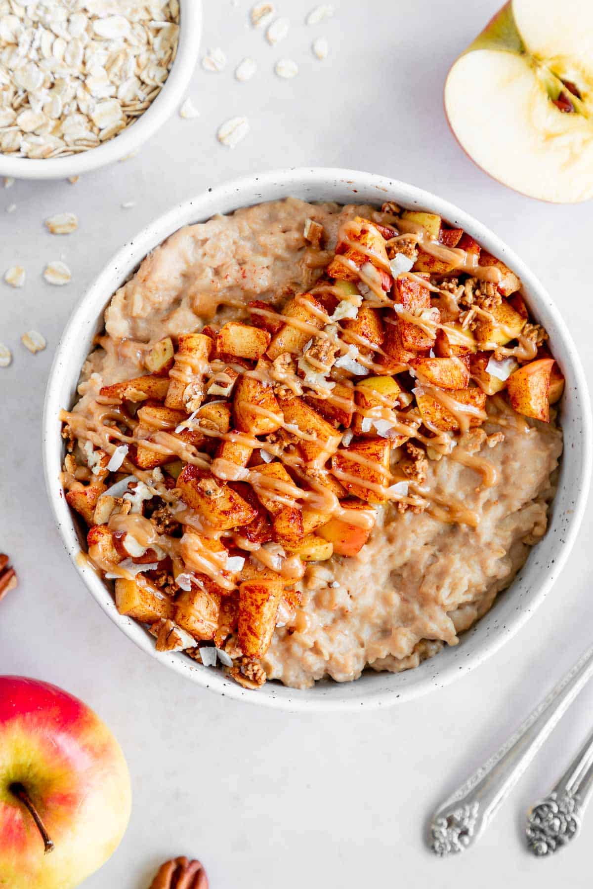 vegan caramel apple oatmeal in a bowl with caramelized apples and healthy caramel sauce on top