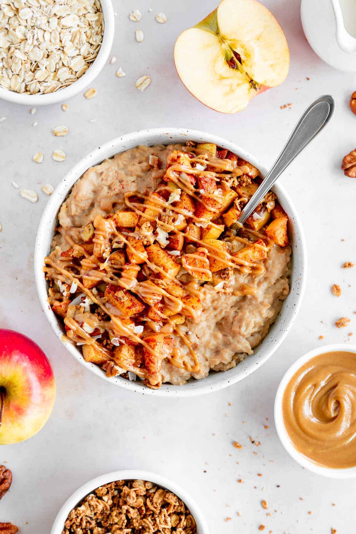 a bowl of vegan caramel apple oatmeal with a spoon inside