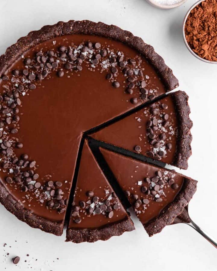a partially sliced no-bake vegan chocolate tart