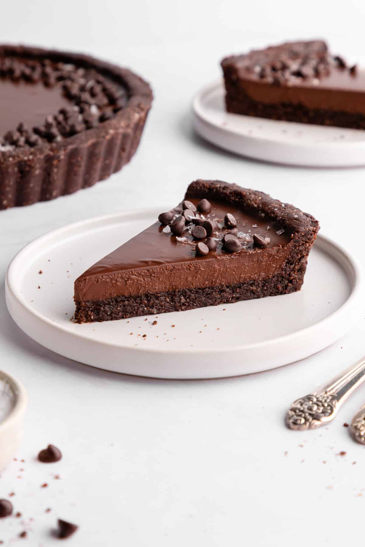 a slice of no-bake vegan chocolate tart on a white plate