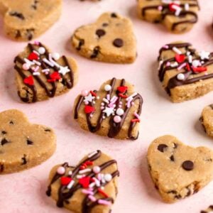 vegan cookie dough hearts with valentine's day sprinkles on a pink surface