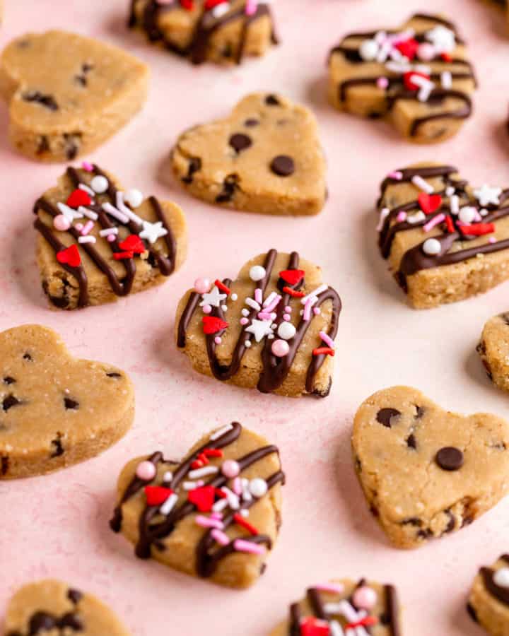 vegan cookie dough hearts with valentine's day sprinkles on a pink surface