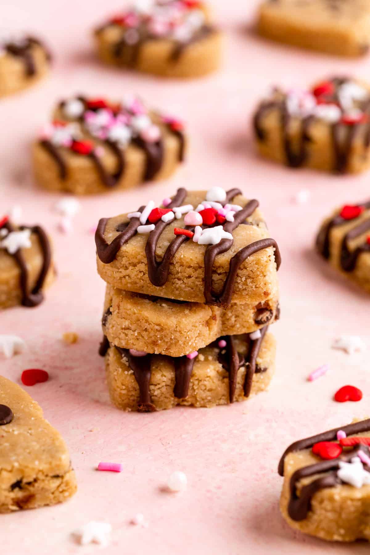 a stack of healthy cookie dough hearts with chocolate chips and valentine's day sprinkls
