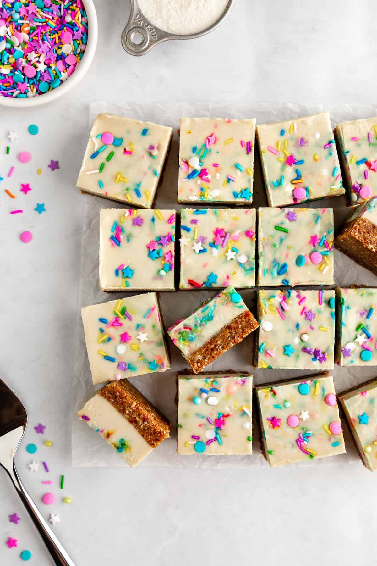 a pile of vegan no-bake funfetti cheesecake bars with birthday sprinkles