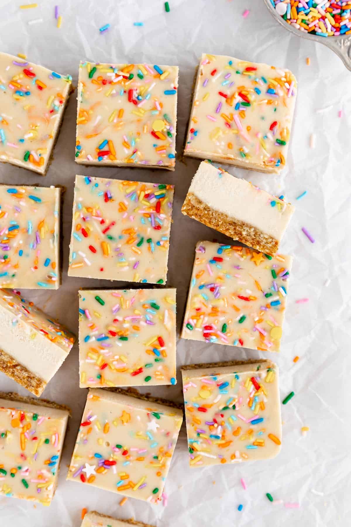 a pile of vegan no-bake funfetti cheesecake bars with birthday sprinkles