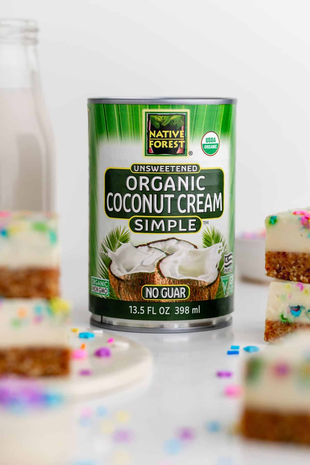 a can of let's do organic coconut cream surrounded by vegan funfetti cheesecake bars