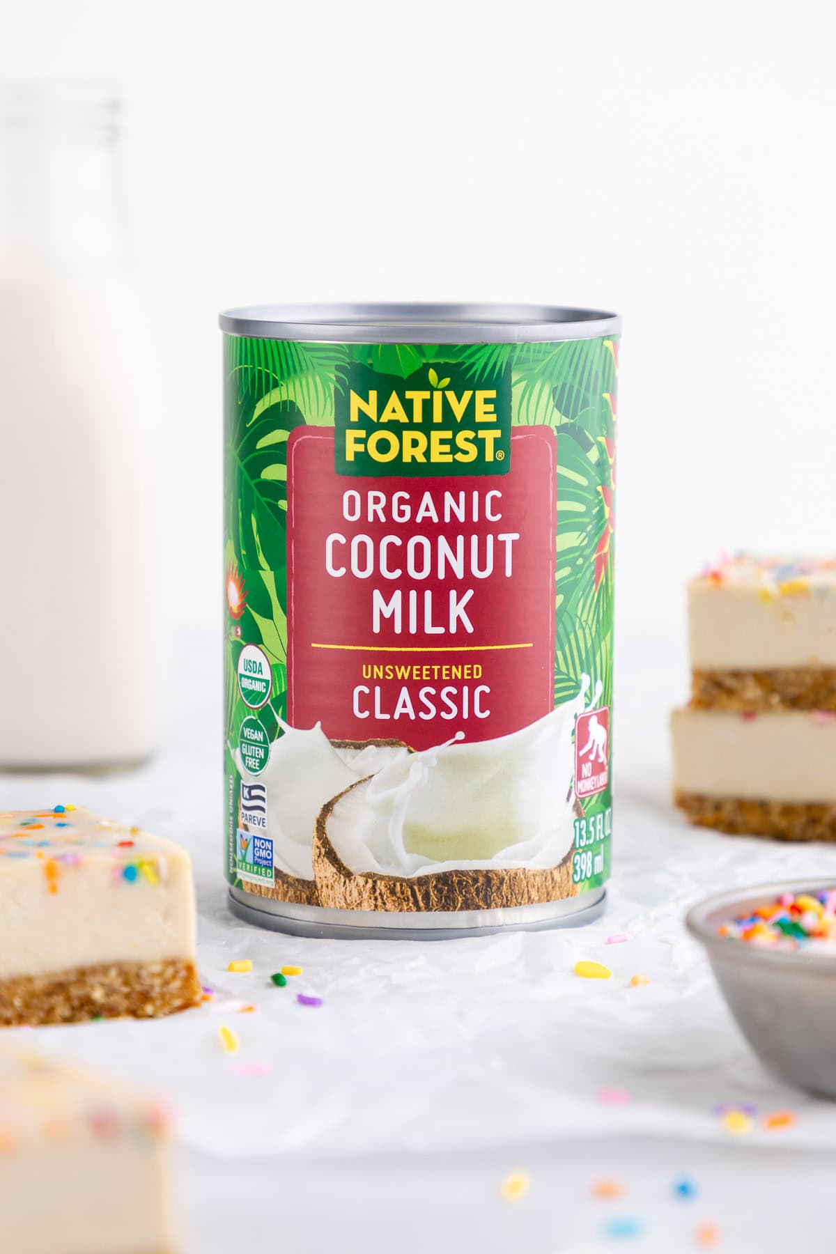 a can of let's do organic coconut cream surrounded by vegan funfetti cheesecake bars