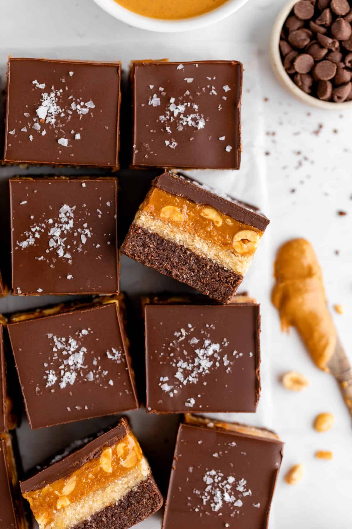 vegan no bake snickers brownies with caramel, peanuts, and nougat
