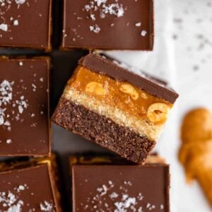 close up photo of no bake snickers brownies with caramel, nougat, peanuts, and chocolate