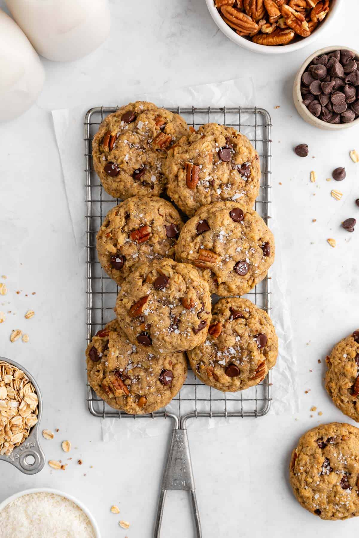 a pile of vegan cowboy cookies on a wire cooling rack