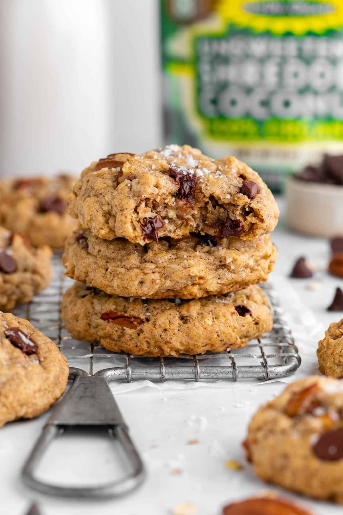 a stack of three vegan cowboy cookies with a bite taken out of the top one