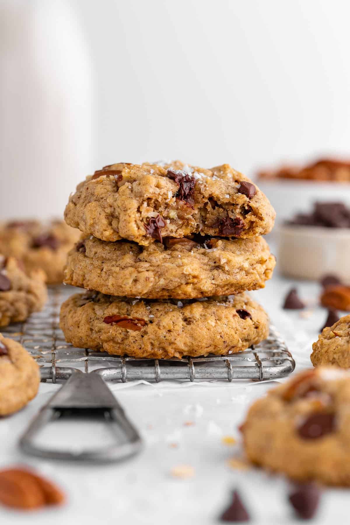 a stack of three vegan cowboy cookies with a bite taken out of the top one