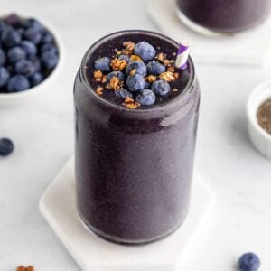 a blueberry spinach smoothie with bananas and chia seeds inside a glass