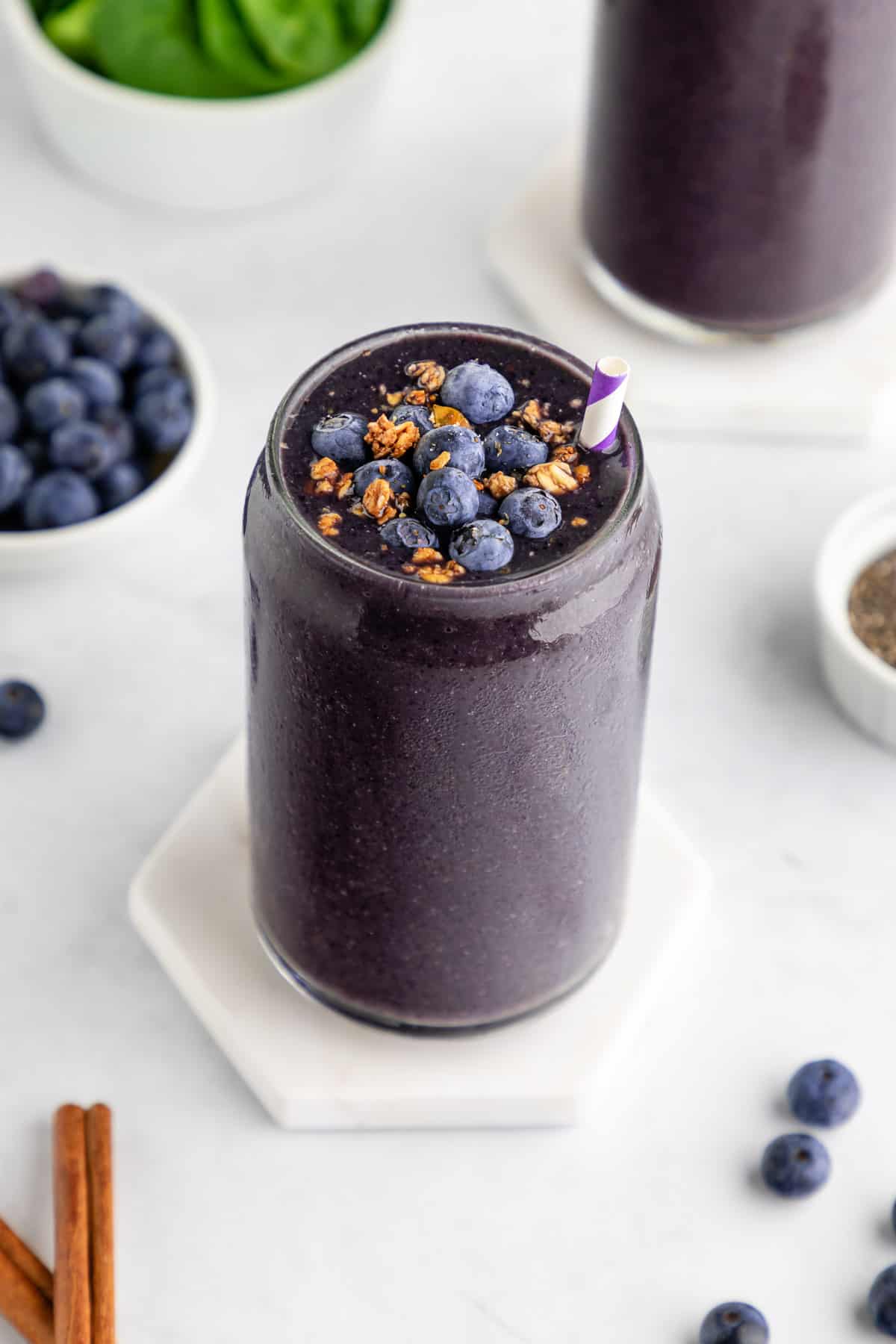 a blueberry spinach smoothie with bananas and chia seeds inside a glass
