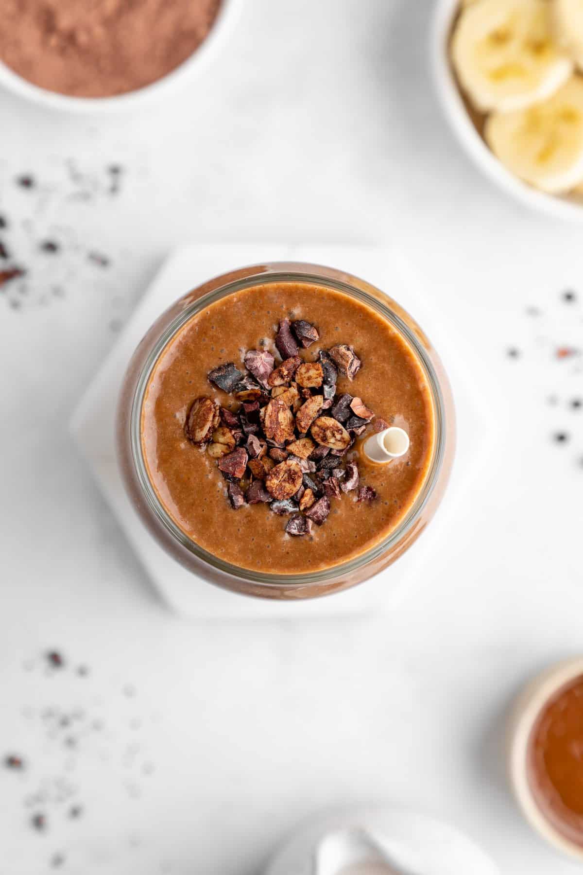 overhead image of a chocolate banana smoothie with cacao nibs on top