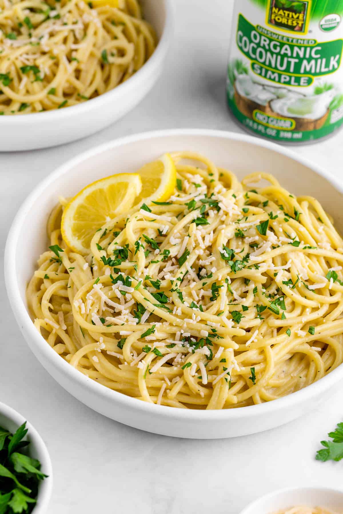 a bowl of creamy lemon pasta alongside a can of coconut milk