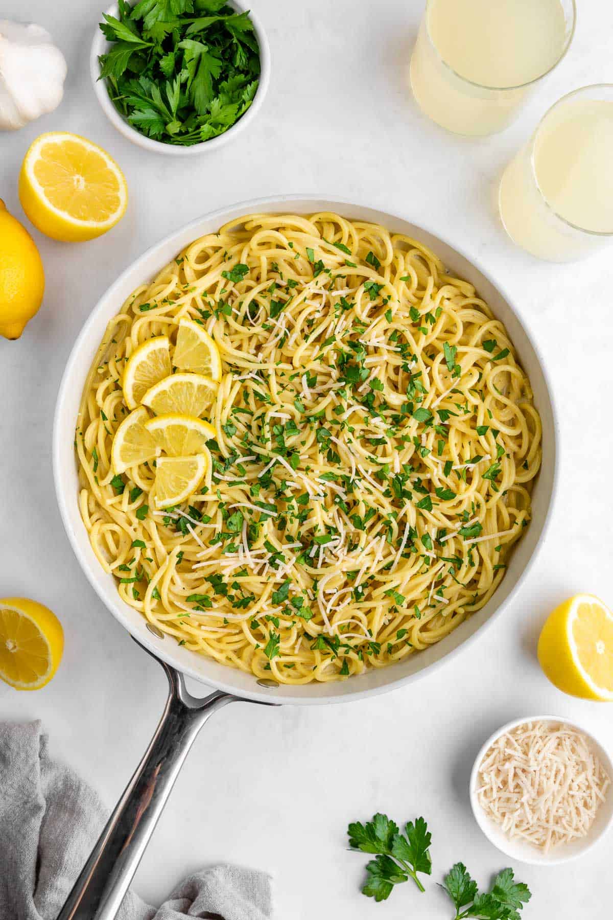 creamy vegan lemon pasta in a pan with coconut milk, lemons, parsley, and parmesan