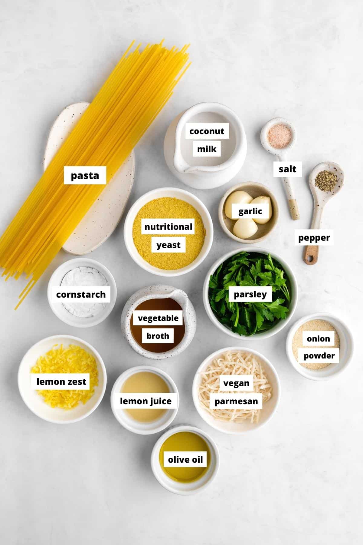 bowls of lemon pasta ingredients including spaghetti, lemon juice, parmesan, olive oil, parsley, and garlic