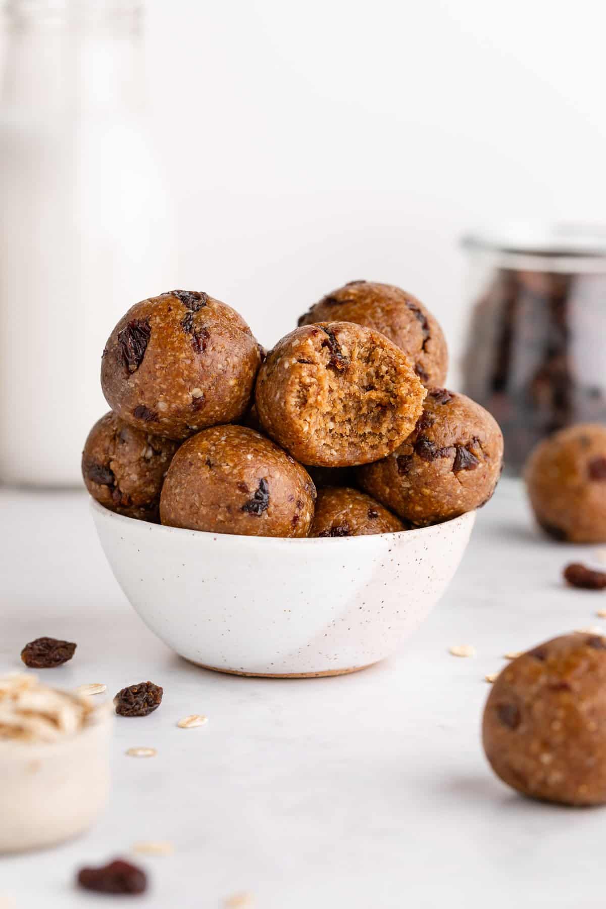 oatmeal raisin energy bites in a small speckled bowl with a bite taken out of the center of one