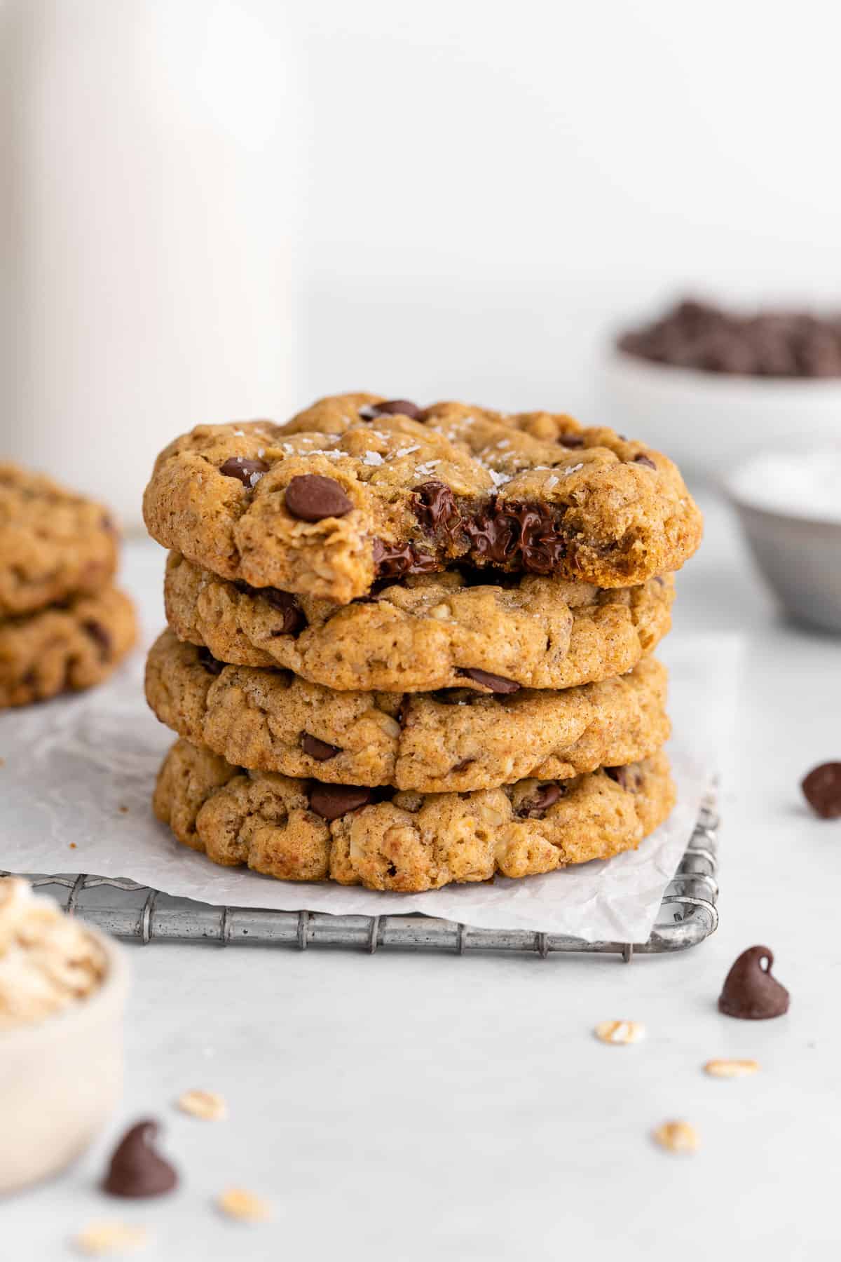a stack of vegan oatmeal chocolate chip cookies with a bite taken out of the top cookie