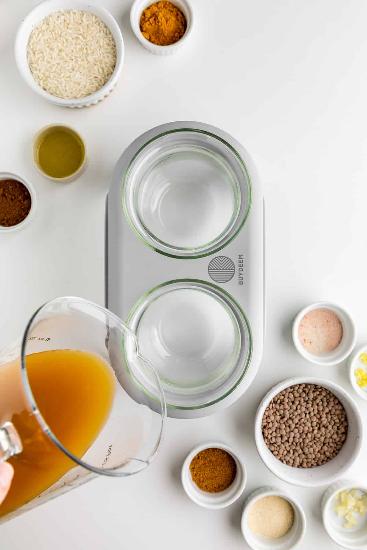 pouring vegetable broth into the Buydeem food steamer stew pots