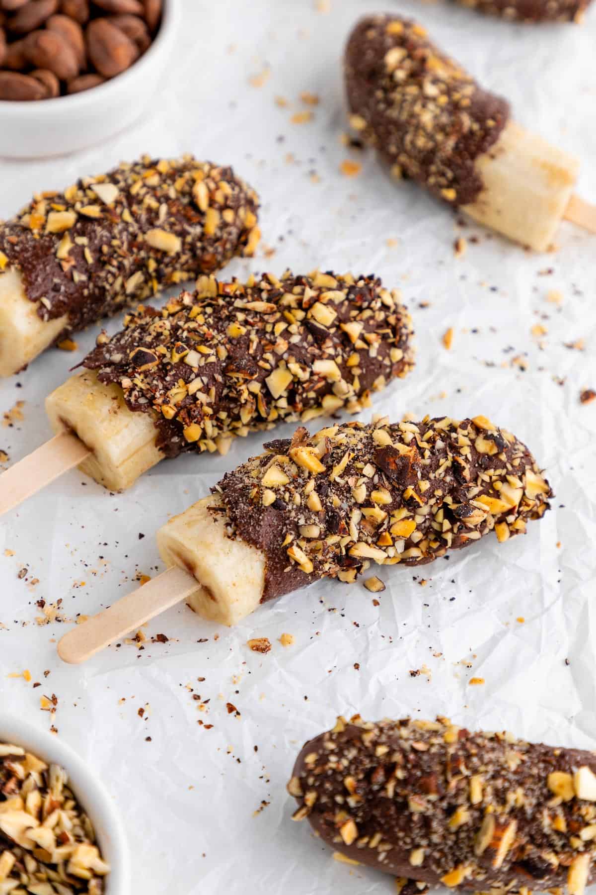 chocolate covered frozen banana pops with crushed nuts