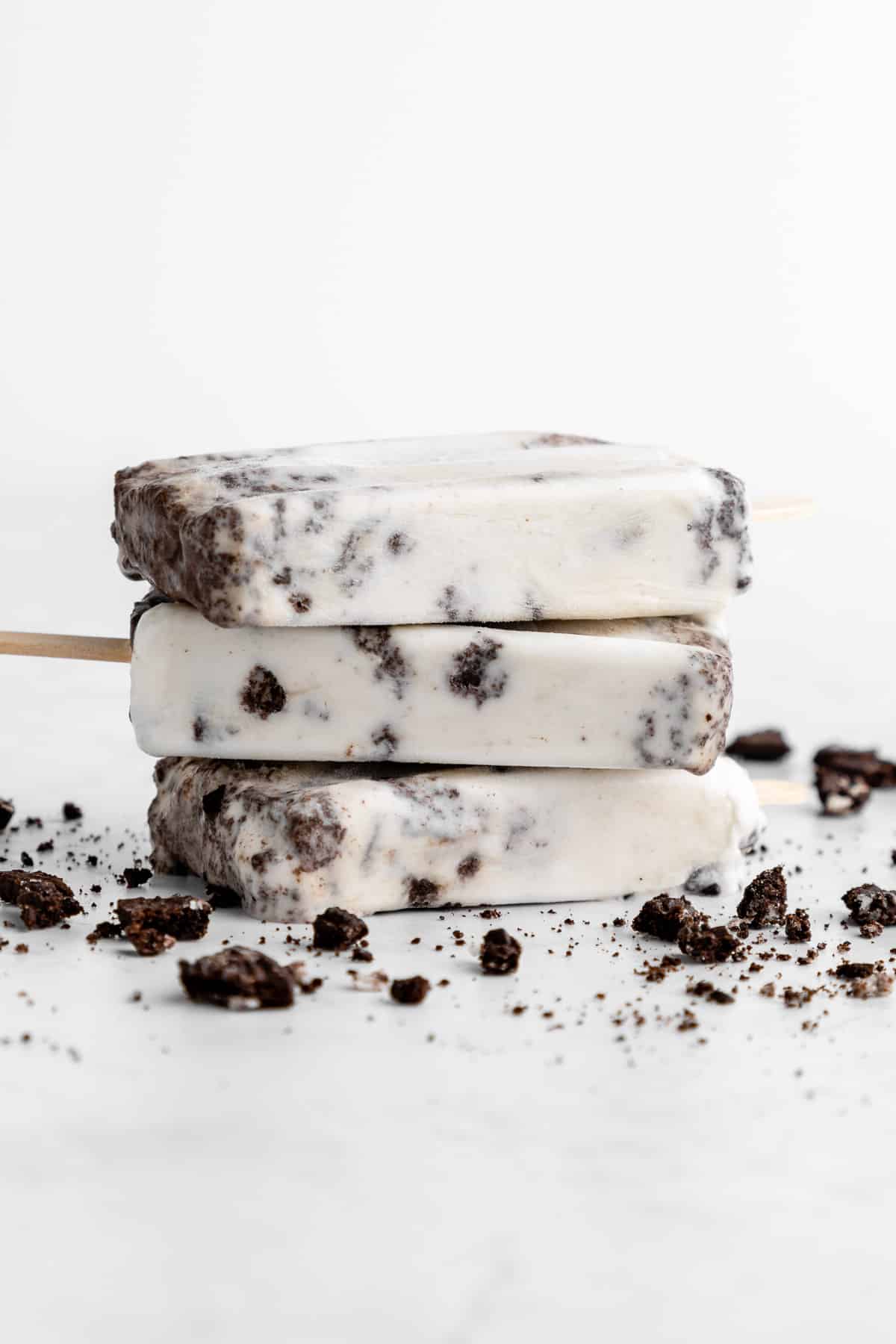 a stack of three vegan cookies and cream popsicles