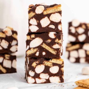 a stack of three vegan s'mores fudge bars with mini marshmallows and graham crackers