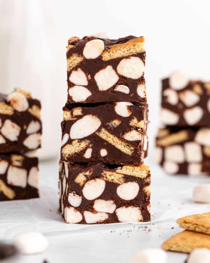 a stack of three vegan s'mores fudge bars with mini marshmallows and graham crackers