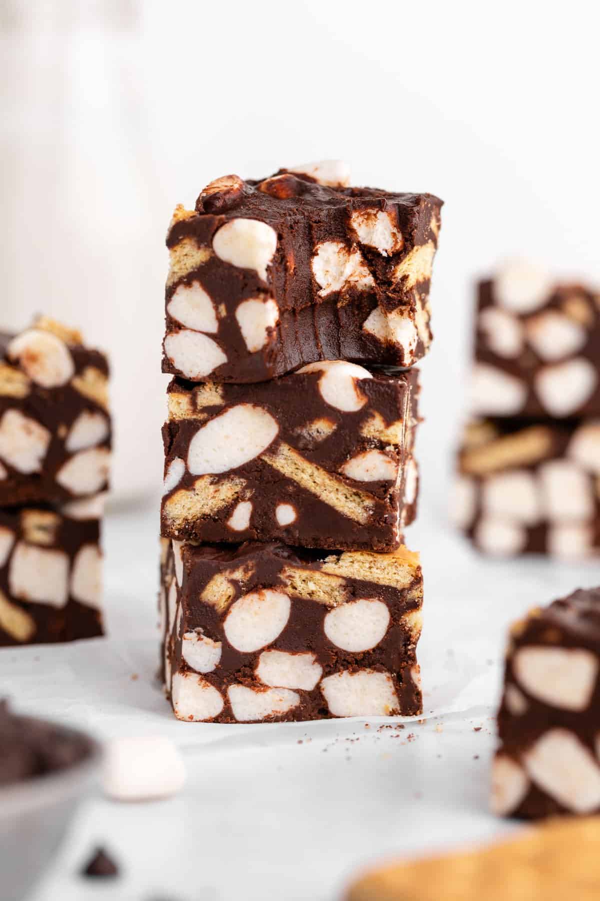 a stack of three vegan s'mores fudge bars with a bite taken out of the top one