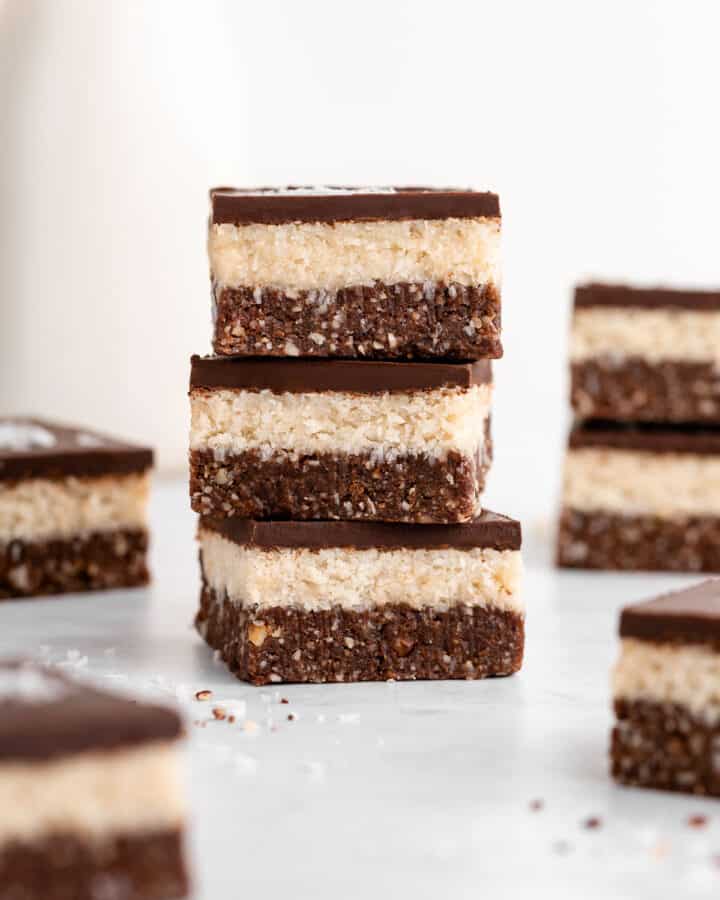 a stack of three layered no-bake coconut brownies