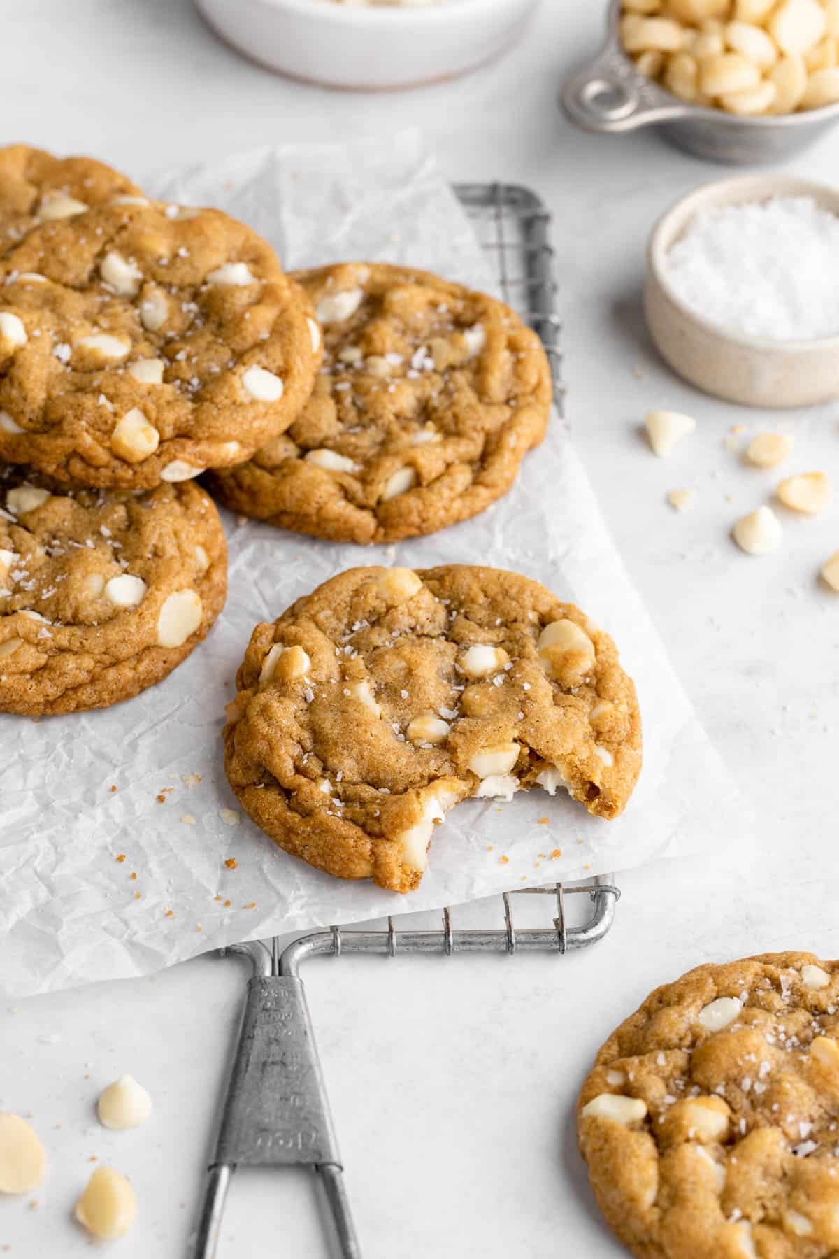 a vegan white chocolate macadamia nut cookie with a bite taken out of the middle