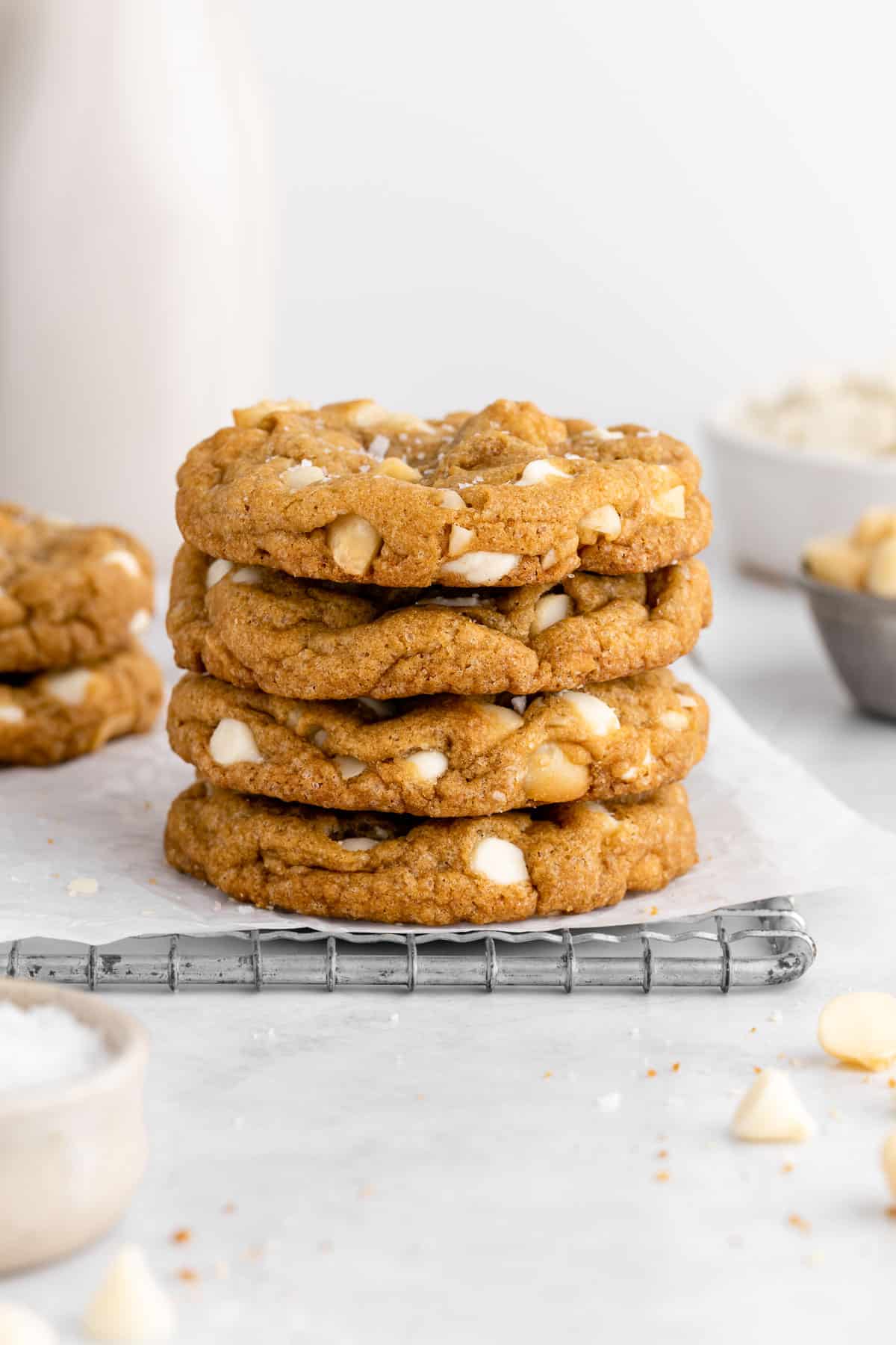 a stack of vegan white chocolate macadamia nut cookies on a wire cooling rack