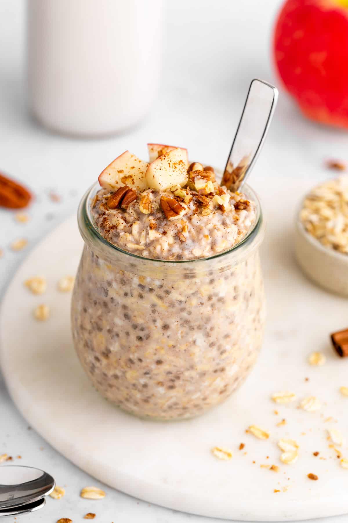 apple cinnamon overnight oats in a jar with diced apples and pecans on top