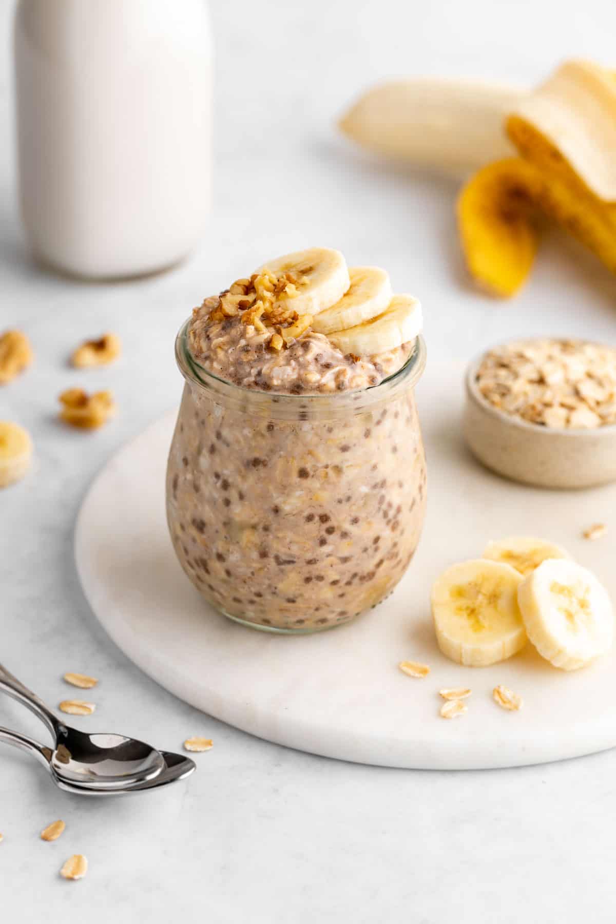 vegan banana overnight oats in a jar with walnuts on top