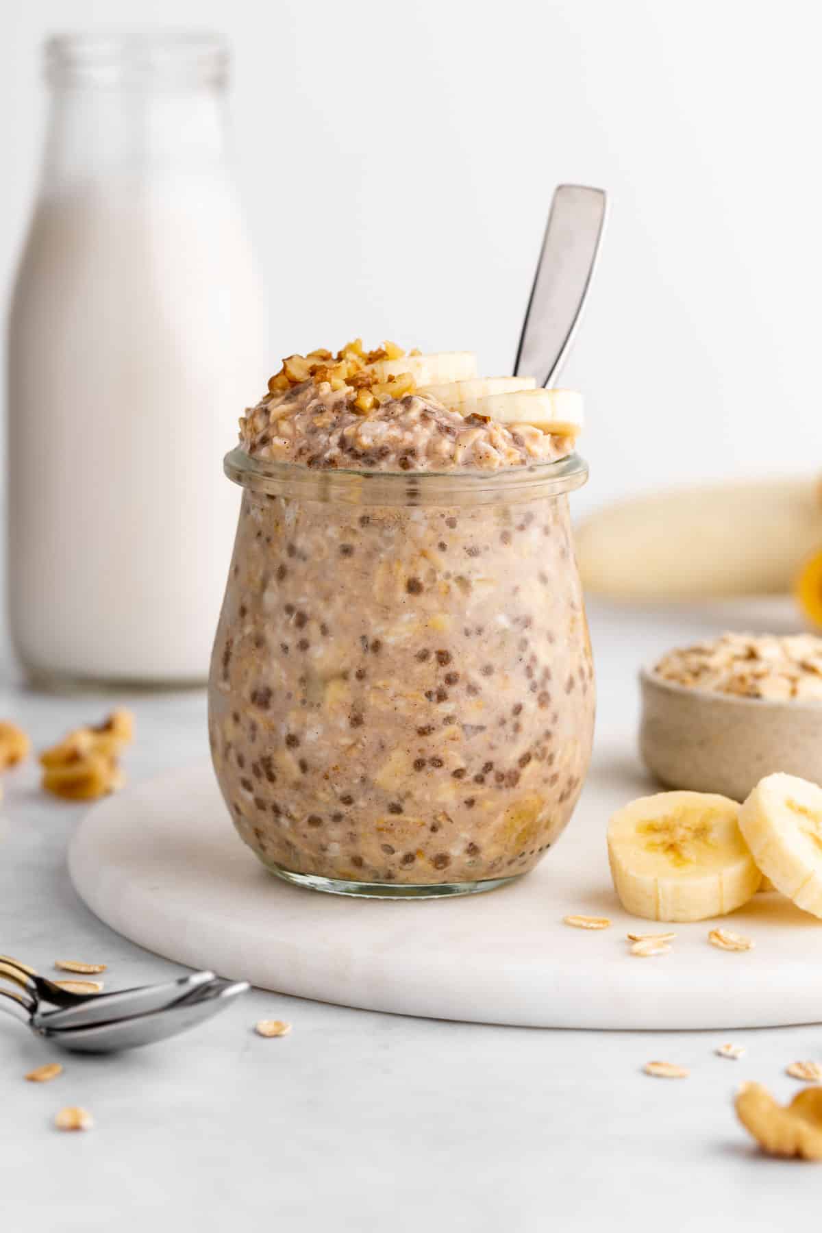 vegan banana overnight oats in a jar with a spoon inserted in the jar