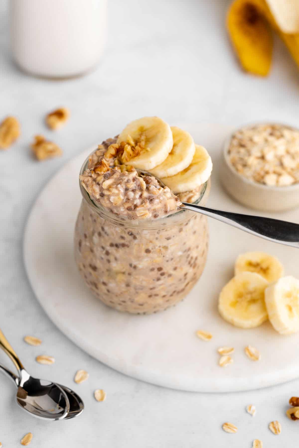 a spoon scooping vegan banana overnight oats out of a jar