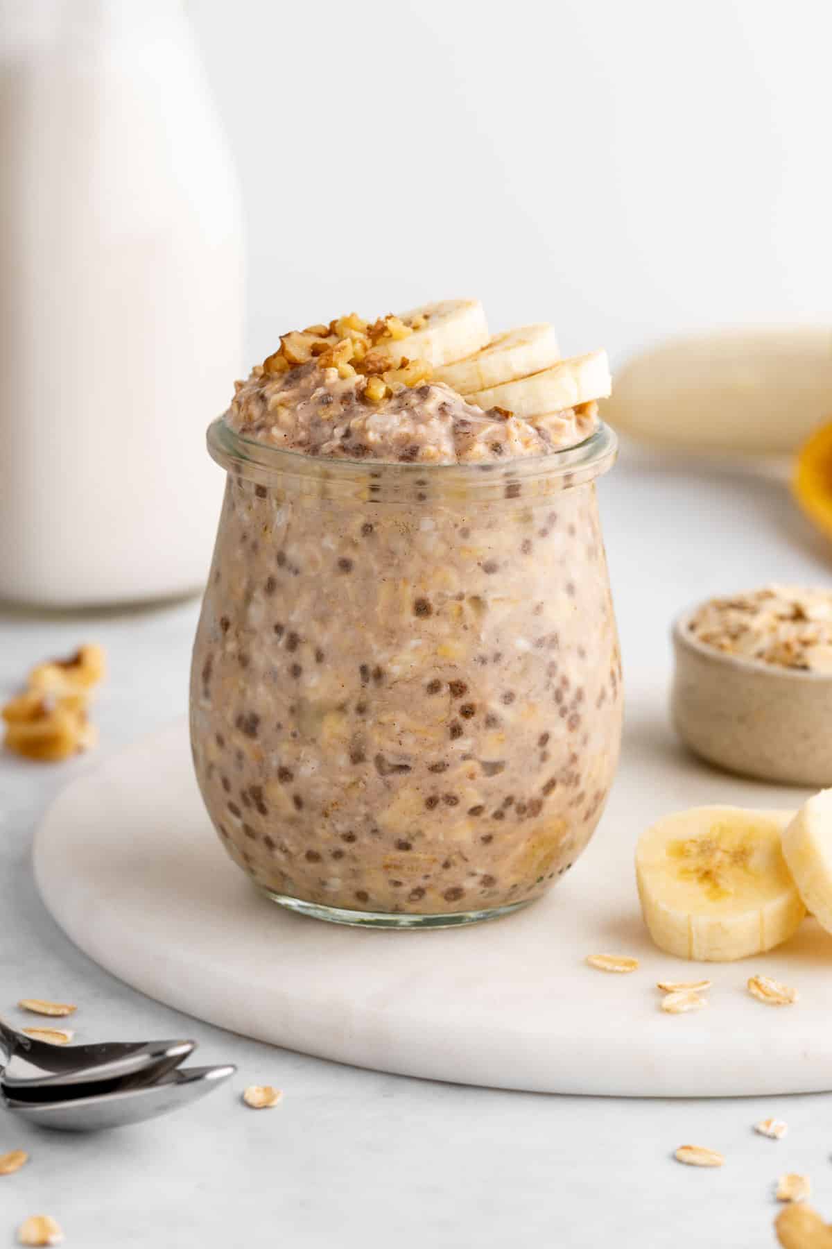 vegan banana overnight oats in a jar with chia seeds, rolled oats, and almond milk