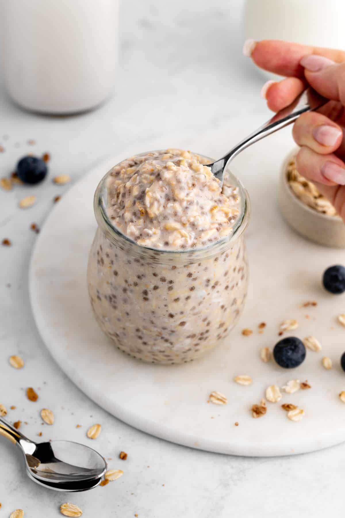 scooping a spoonful of basic overnight oats out of a jar