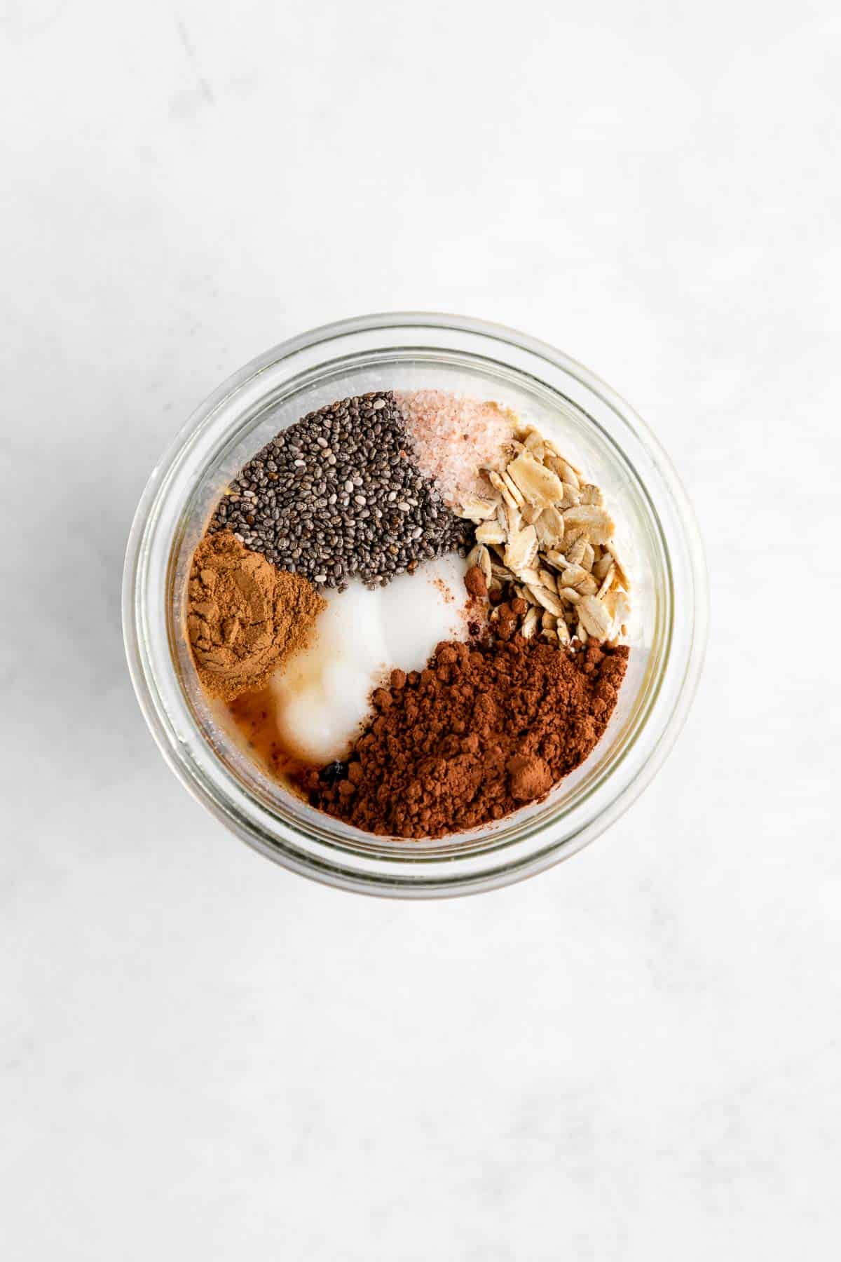 rolled oats, yogurt, cocoa powder, chia seeds, almond milk, and cinnamon in a mason jar