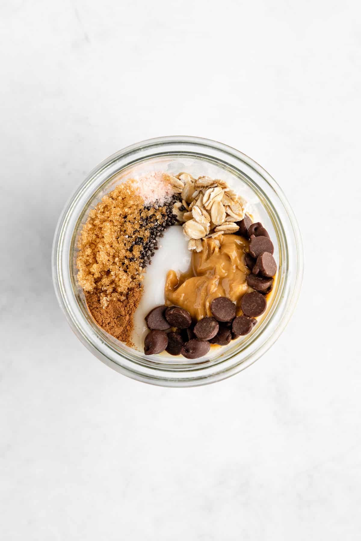 rolled oats, non-dairy yogurt, chia seeds, cashew butter, chocolate chips, brown sugar, and cinnamon in a mason jar