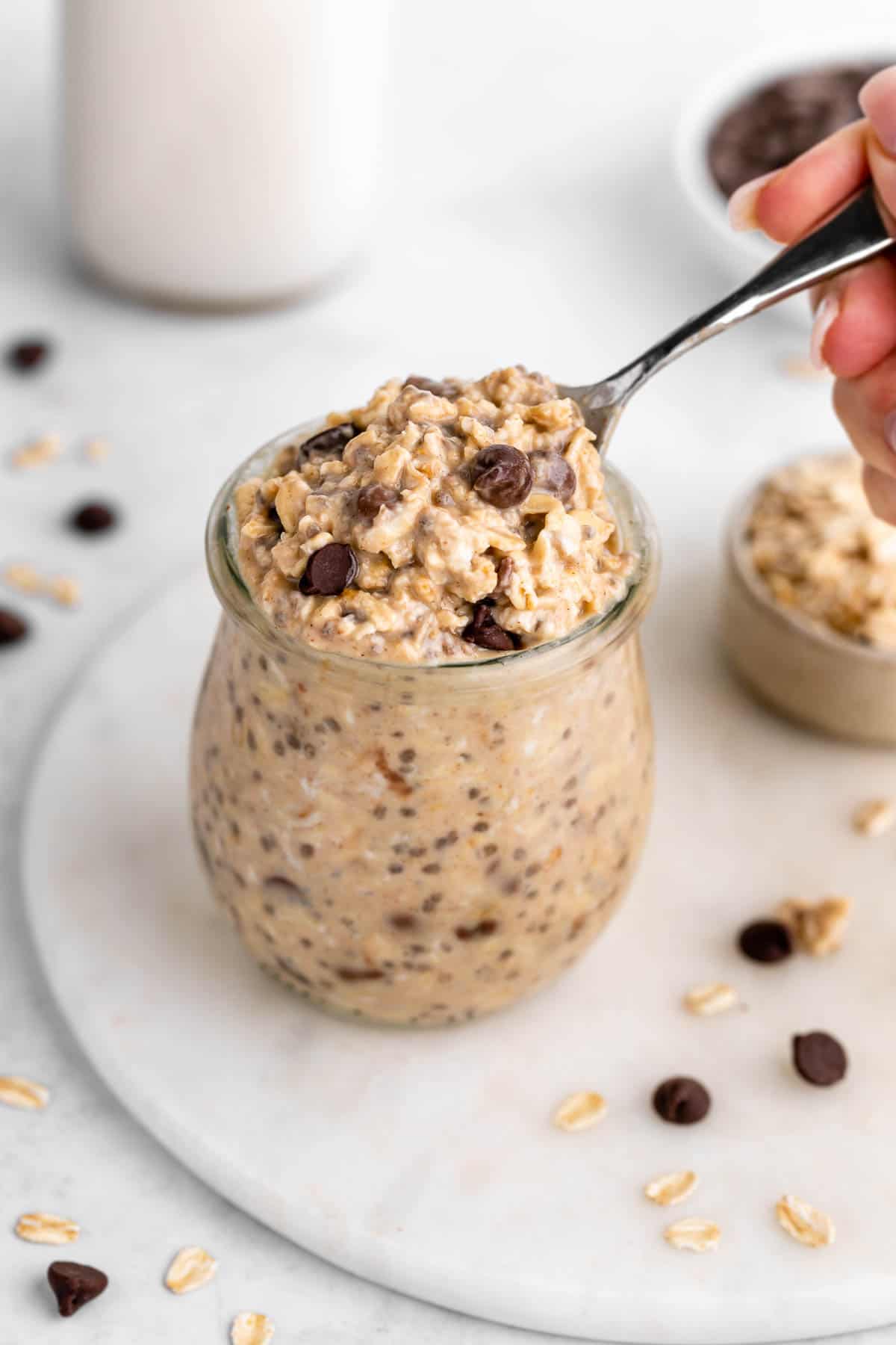 a spoon scooping into a jar of vegan chocolate chip cookie dough overnight oats