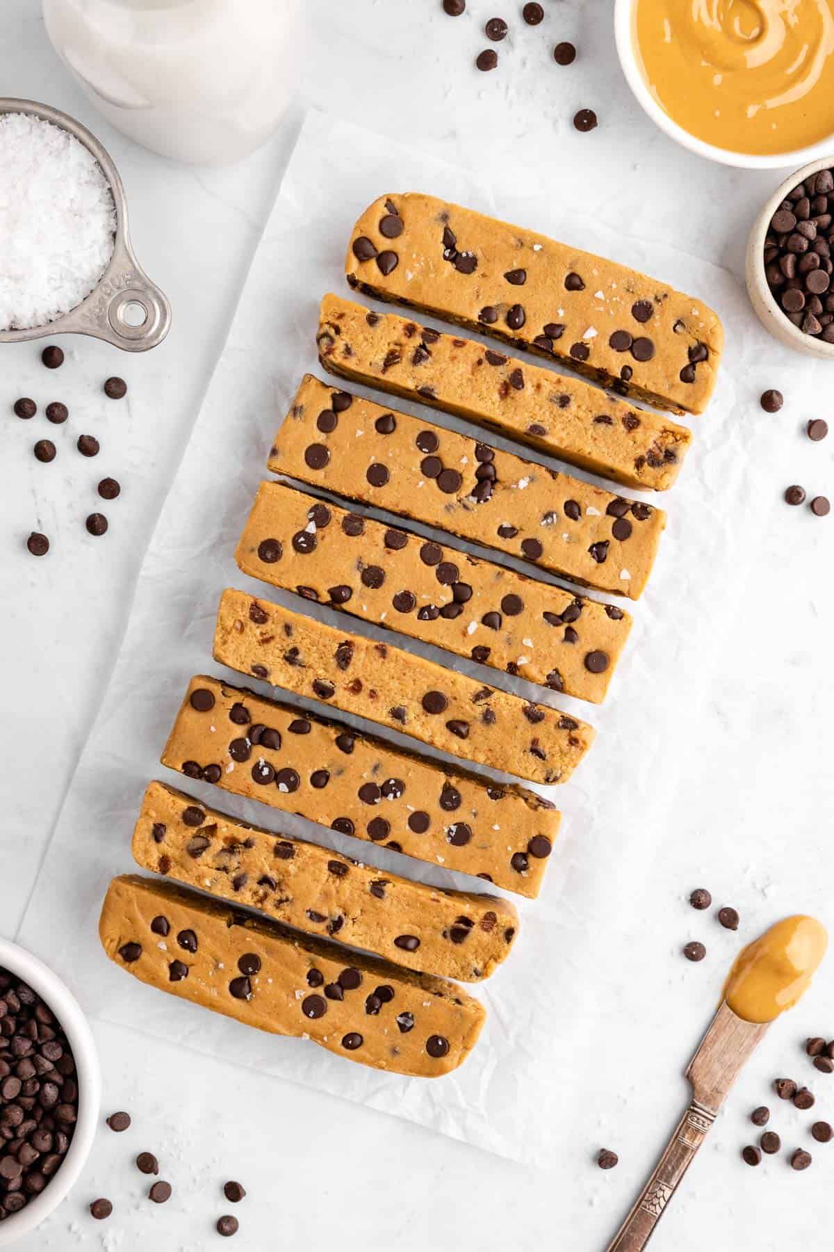 a pile of sliced homemade cookie dough protein bars with chocolate chips, almond flour, and cashew butter